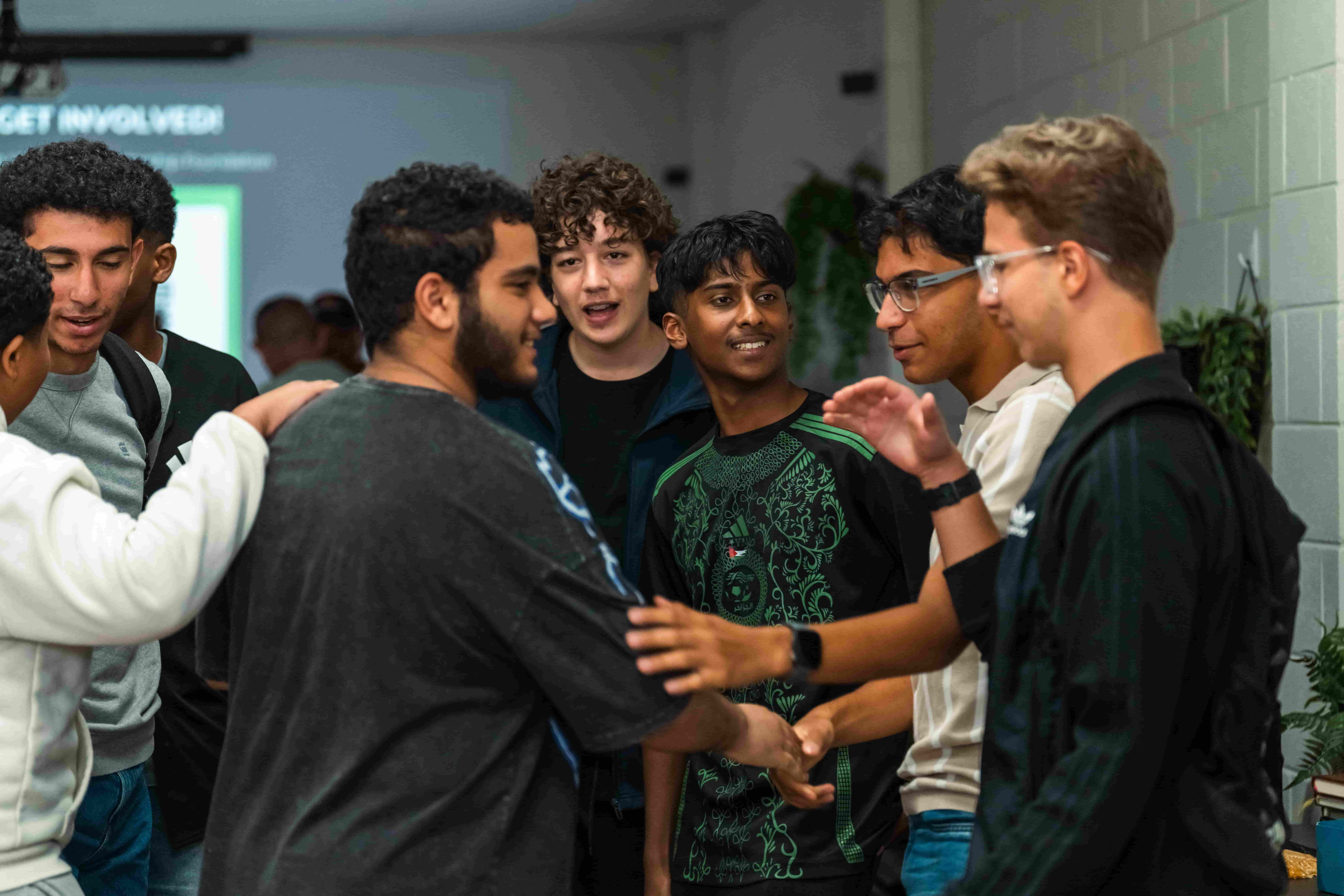 Young people greeting each other with handshakes at a UMF session